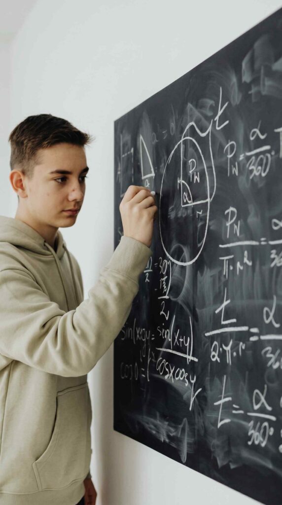 Étudiant en classe préparatoire travaillant sur un problème de mathématiques au tableau